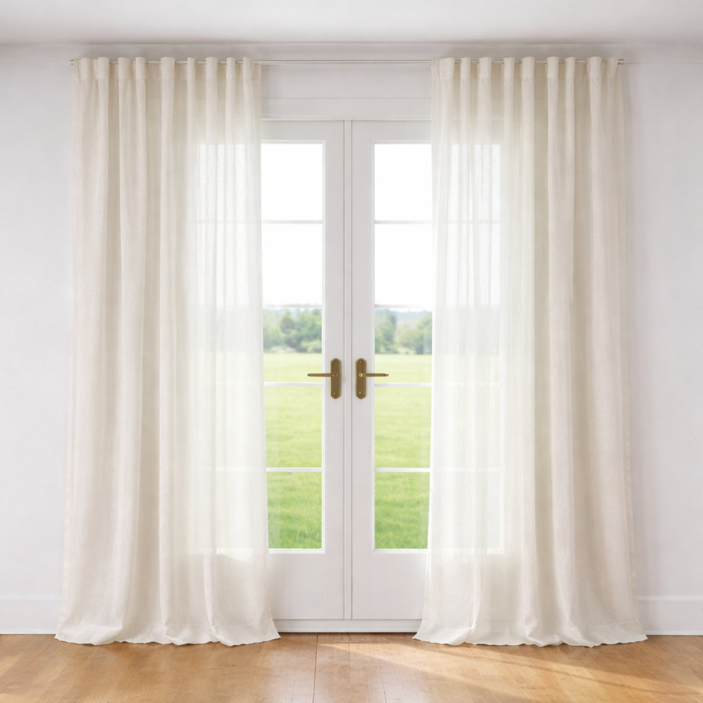 Ann Gish Veil ivory sheer linen curtain panels framing French doors in a sunlit room.