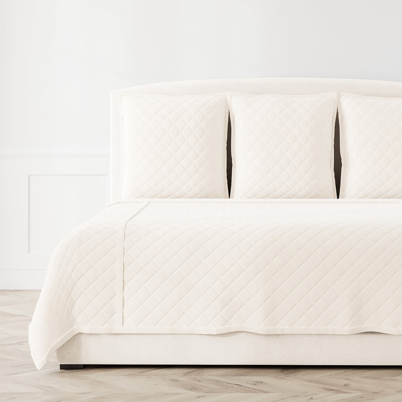 Ivory velvet coverlet set with diamond quilting, styled on a bed with matching shams.