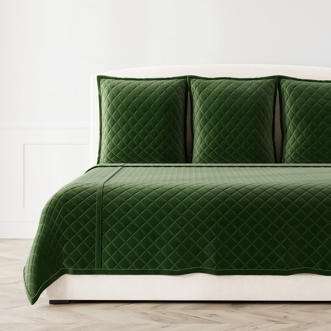 Forest green velvet coverlet set with diamond quilting, styled on a bed with matching shams.