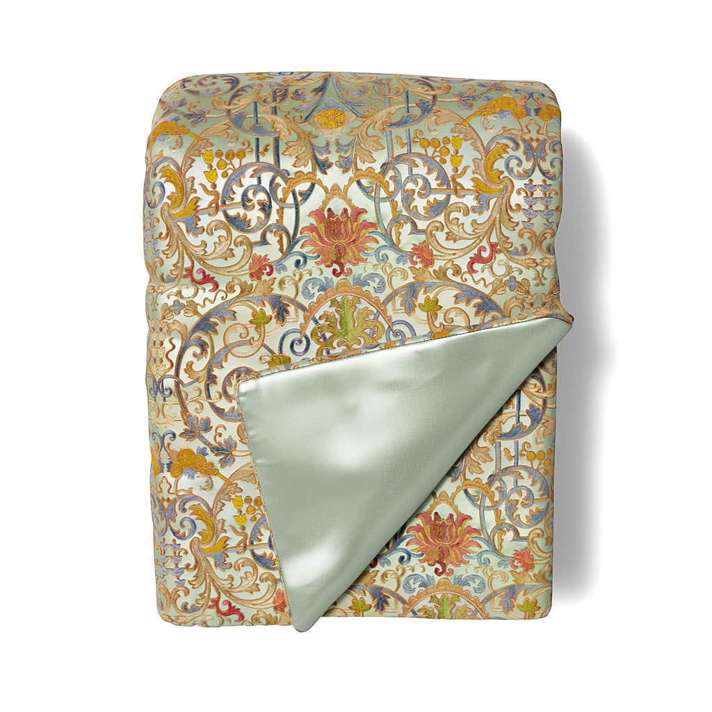 Ann Gish Venezia throw folded, revealing sage satin reverse against ornate floral scroll pattern.