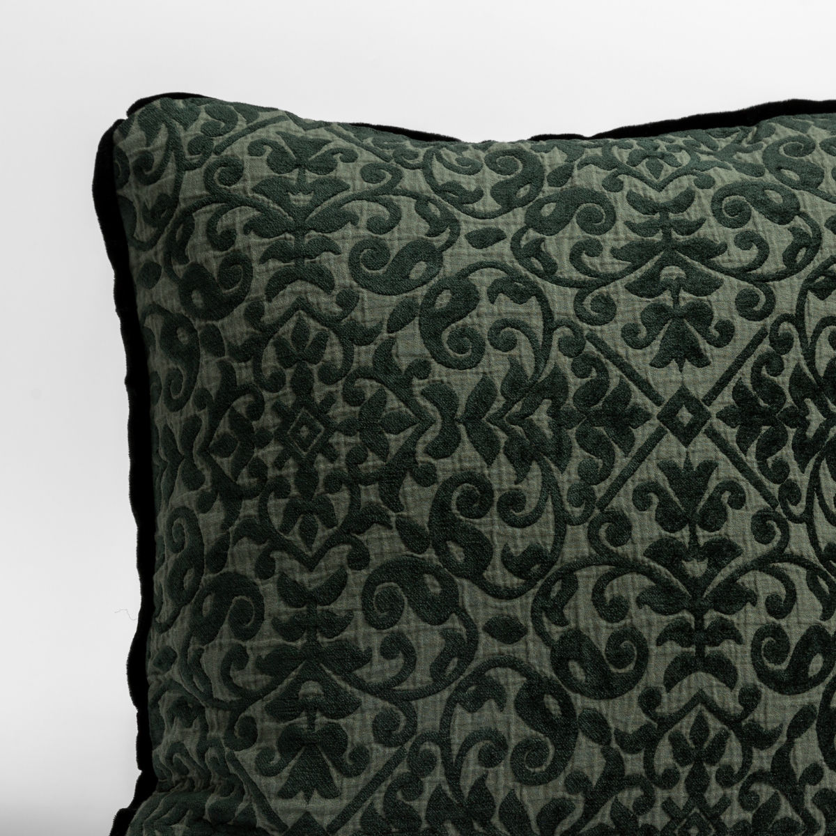 Close-up of Vienna sham corner in Juniper, showing damask velvet pattern and dark piped trim.