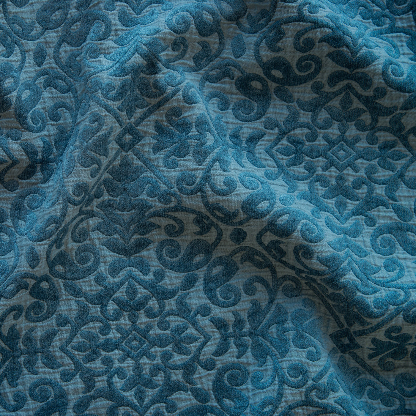 Close-up of Bella Notte Vienna coverlet in Cenote, showing draped damask velvet texture.
