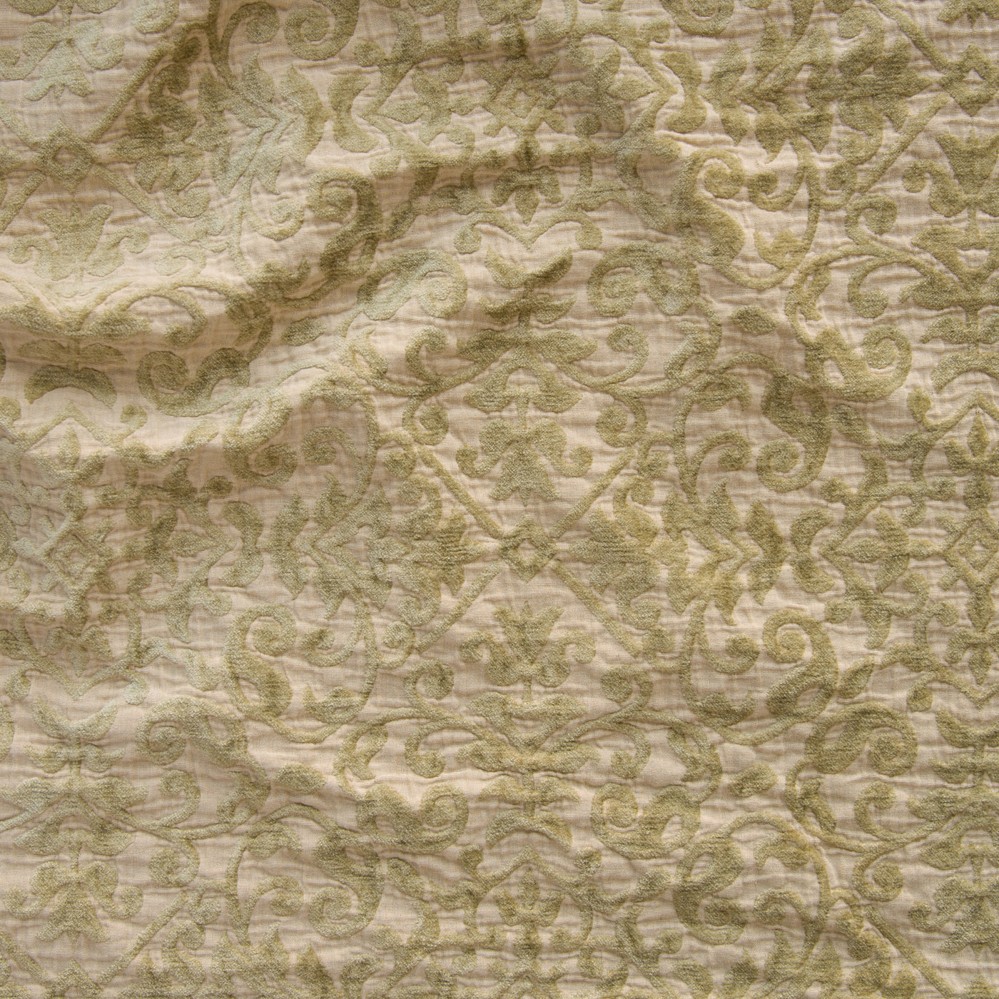 Close-up of Bella Notte Vienna sham in Honeycomb, showing scrolling damask embroidery on draped fabric.