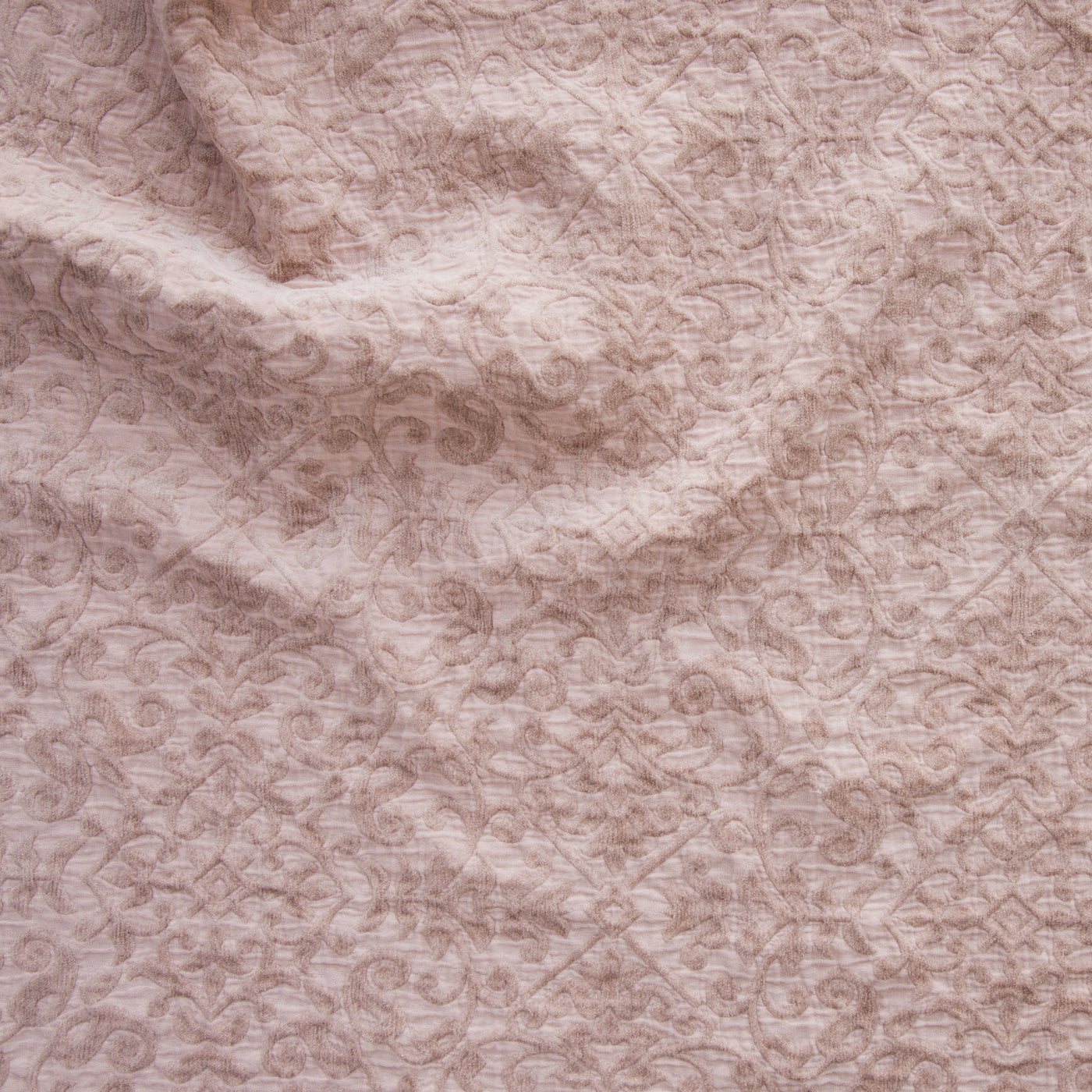 Close-up of Vienna sham fabric in blush, showing tonal scroll and floral jacquard weave texture.