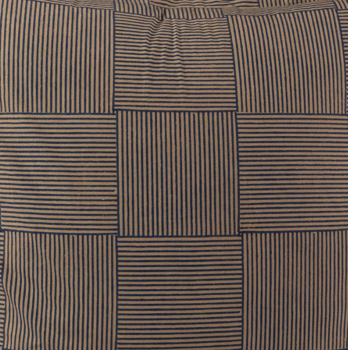 Close-up of alternating grid blocks with navy and tan vertical stripes on woven textile.