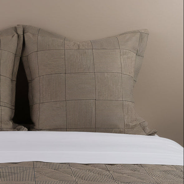 Close-up of Henry Handwork Wabi Sabi euro sham, tan and black striped block pattern.