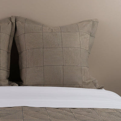 Close-up of Henry Handwork Wabi Sabi euro sham, tan and black striped block pattern.