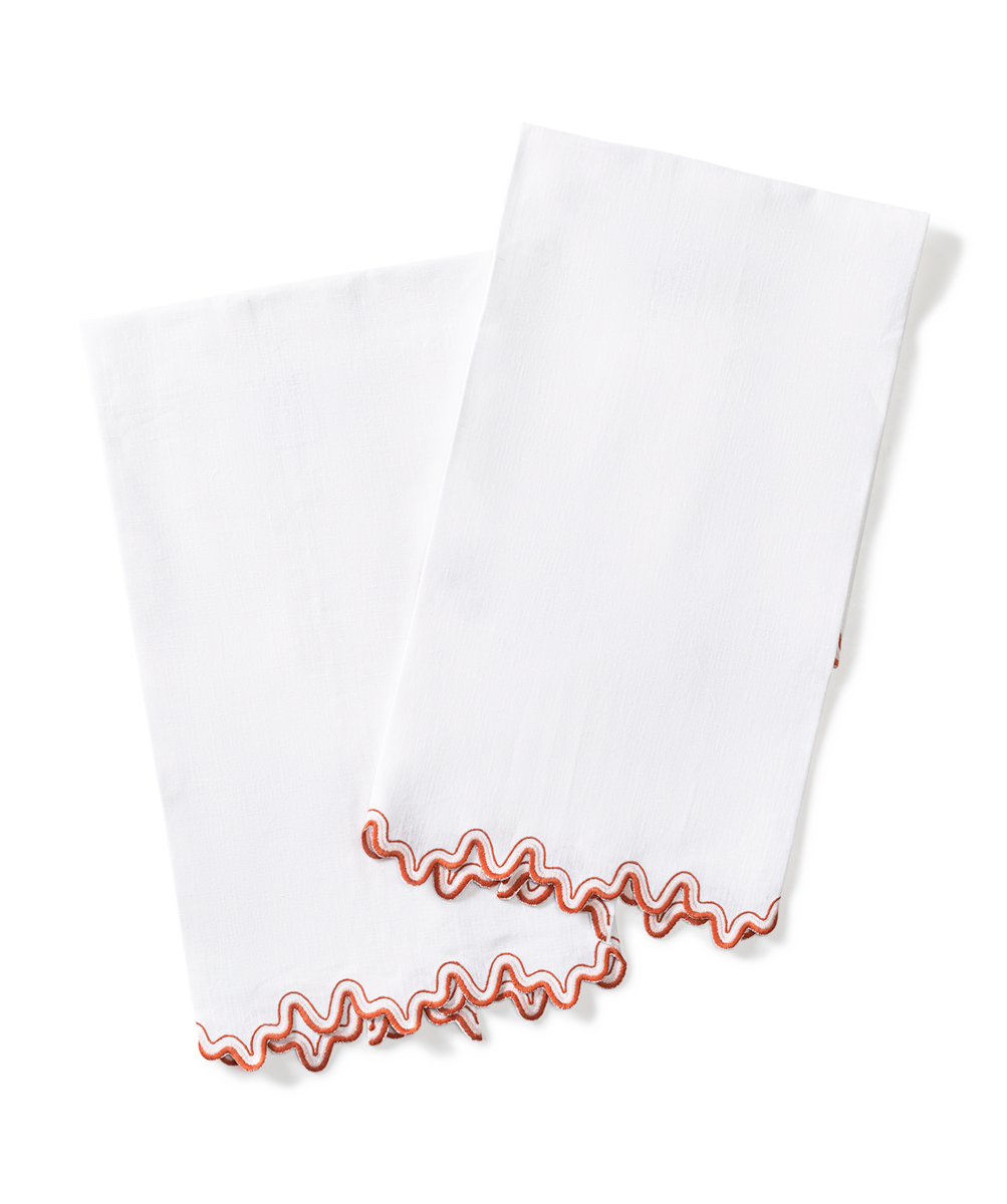 The Wave | Linen Guest Towel Set by Matouk features two white linen towels with a wavy red two-tone border, shown overlapping on a plain background—an elegant accent for any embroidered tabletop decor.