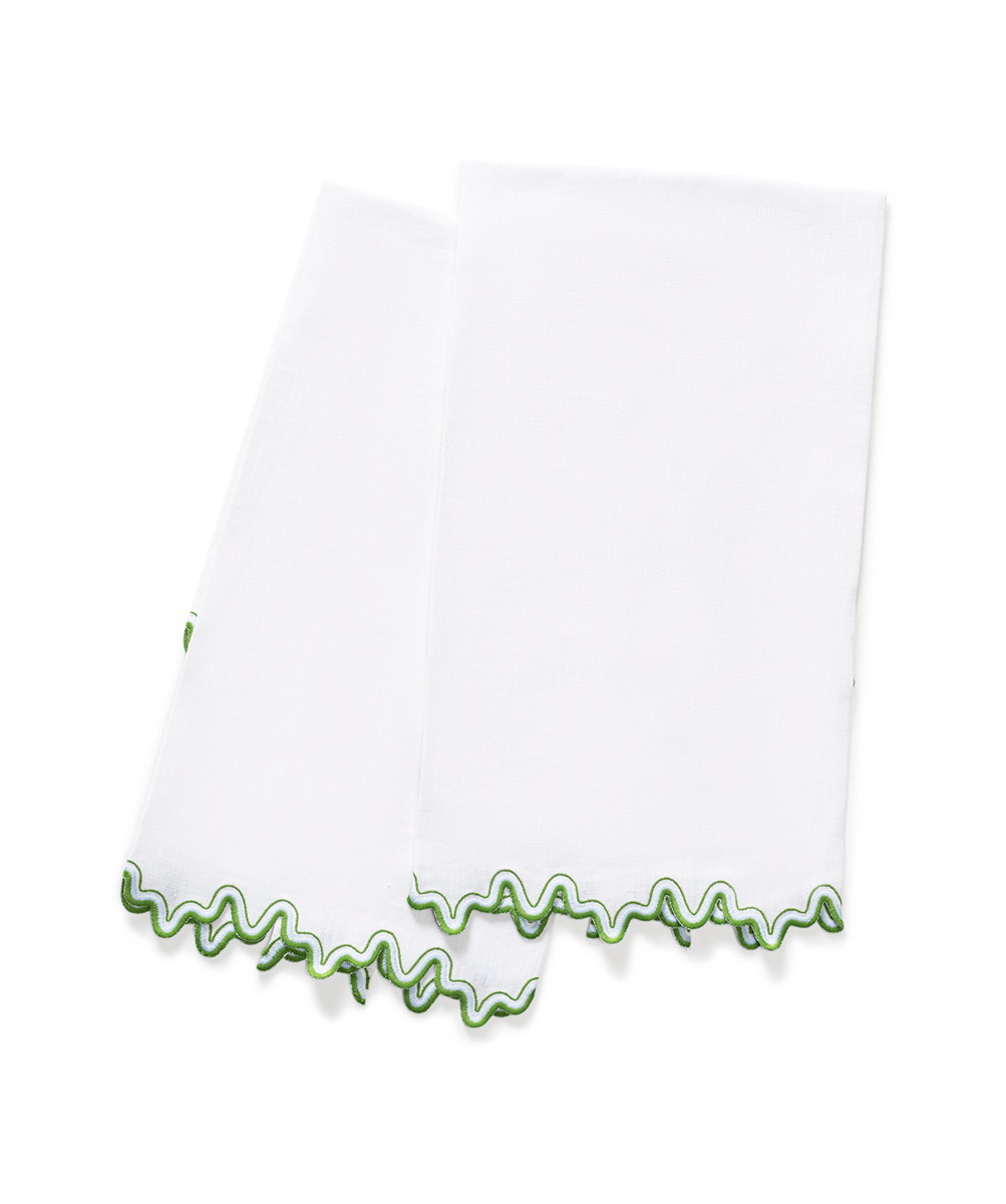 The Wave | Linen Guest Towel Set by Matouk features two white linen towels with a wavy green trim, elegantly displayed overlapping on a plain white background—perfect for adding style to any embroidered tabletop.