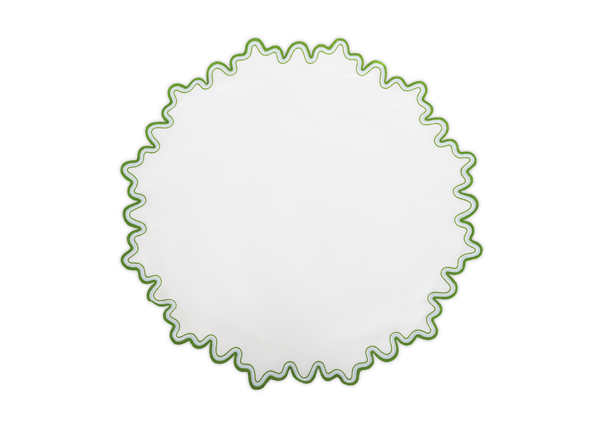 The Matouk Wave placemat features a round white linen design with a wavy green two-tone border, combining elegance and luxury.