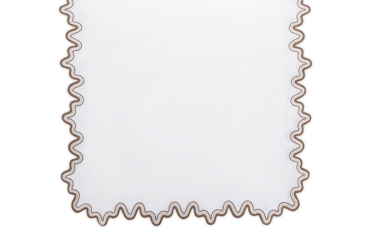 The Matouk Wave Tablecloth Runner, a white rectangular linen piece with a wavy two-tone border, is displayed on a plain background.