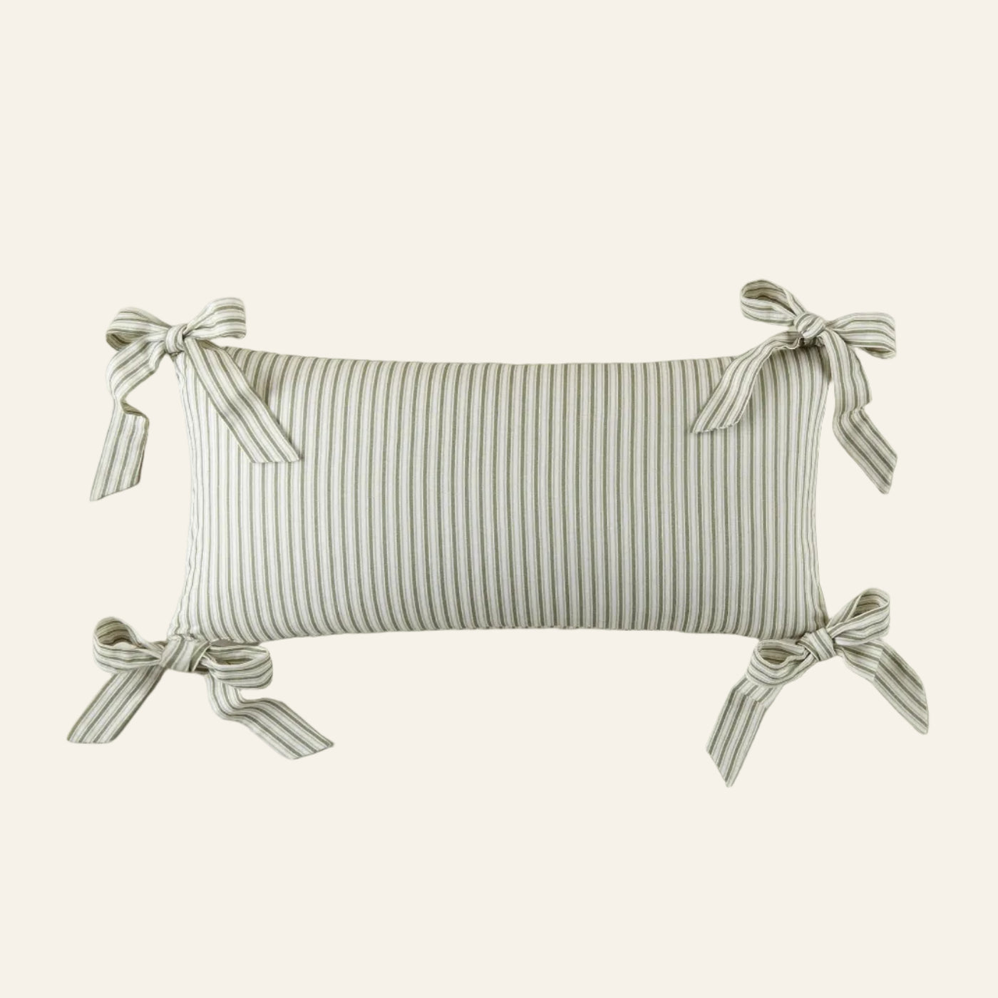 Striped pillow with ribbon ties on a beige background
