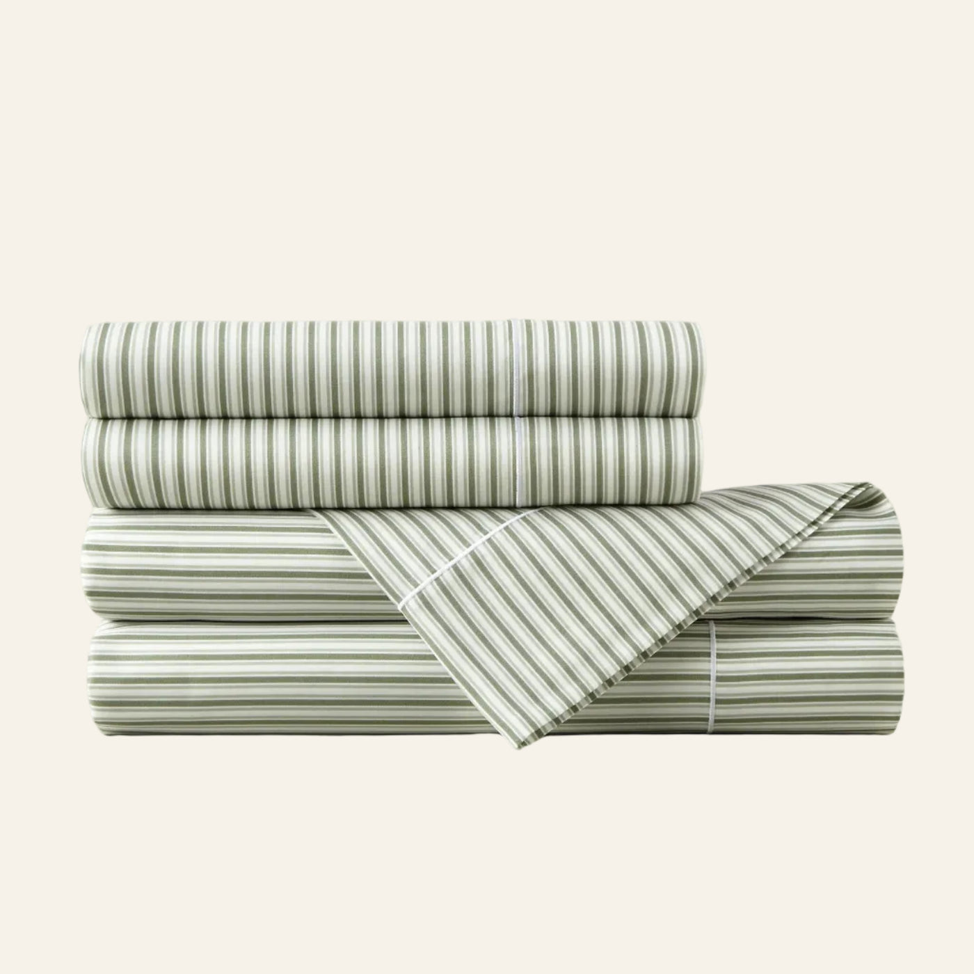 Stack of green and white striped bed sheets on a light beige background