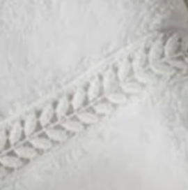 Close-up of ivory cotton terry with woven laurel wreath border detail.