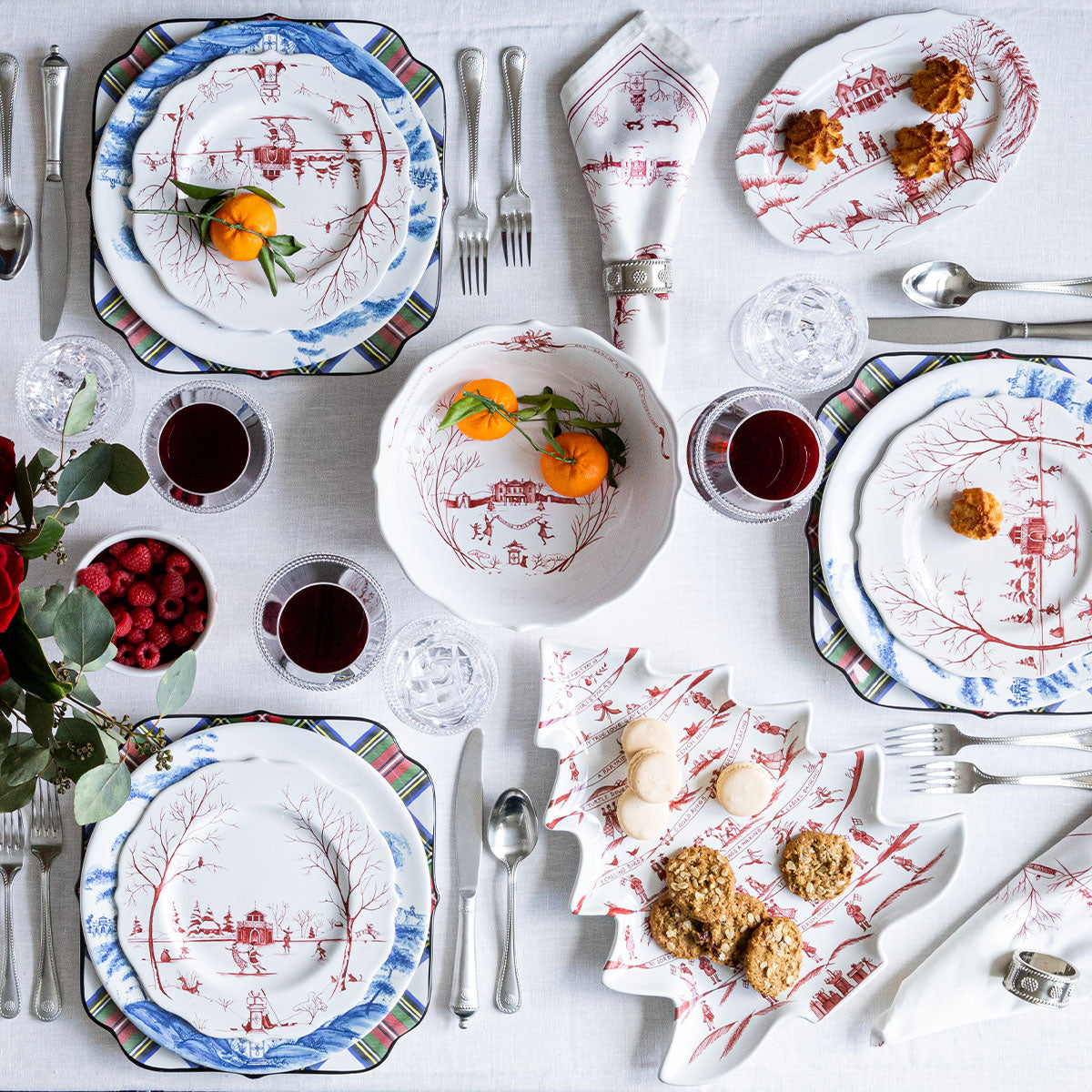 Overhead table with a ruby Winter Frolic tree platter of cookies and blue and white plates