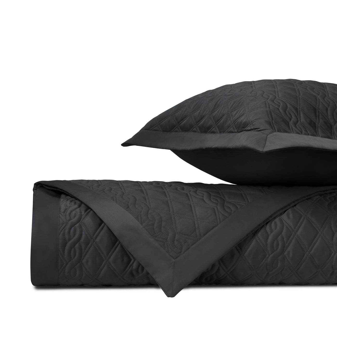 Close-up of Abbey quilted coverlet in black with diamond and scroll stitching detail.