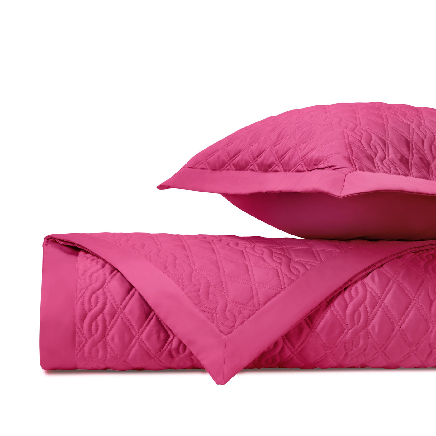 Fuchsia quilted fabric folded alongside a matching sham, showing diamond stitch detail.