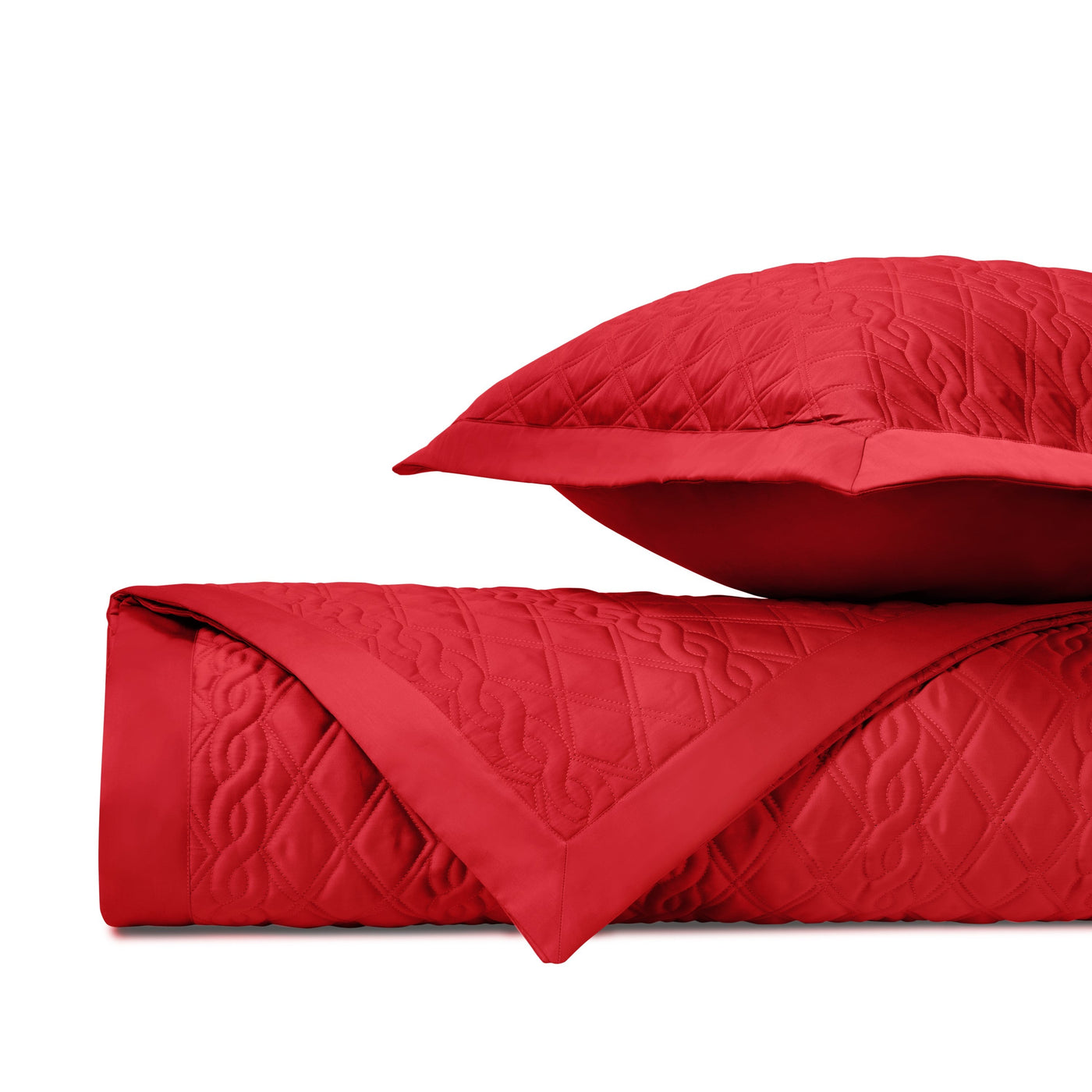 Close-up of crimson quilted coverlet with diamond and scroll stitching pattern.