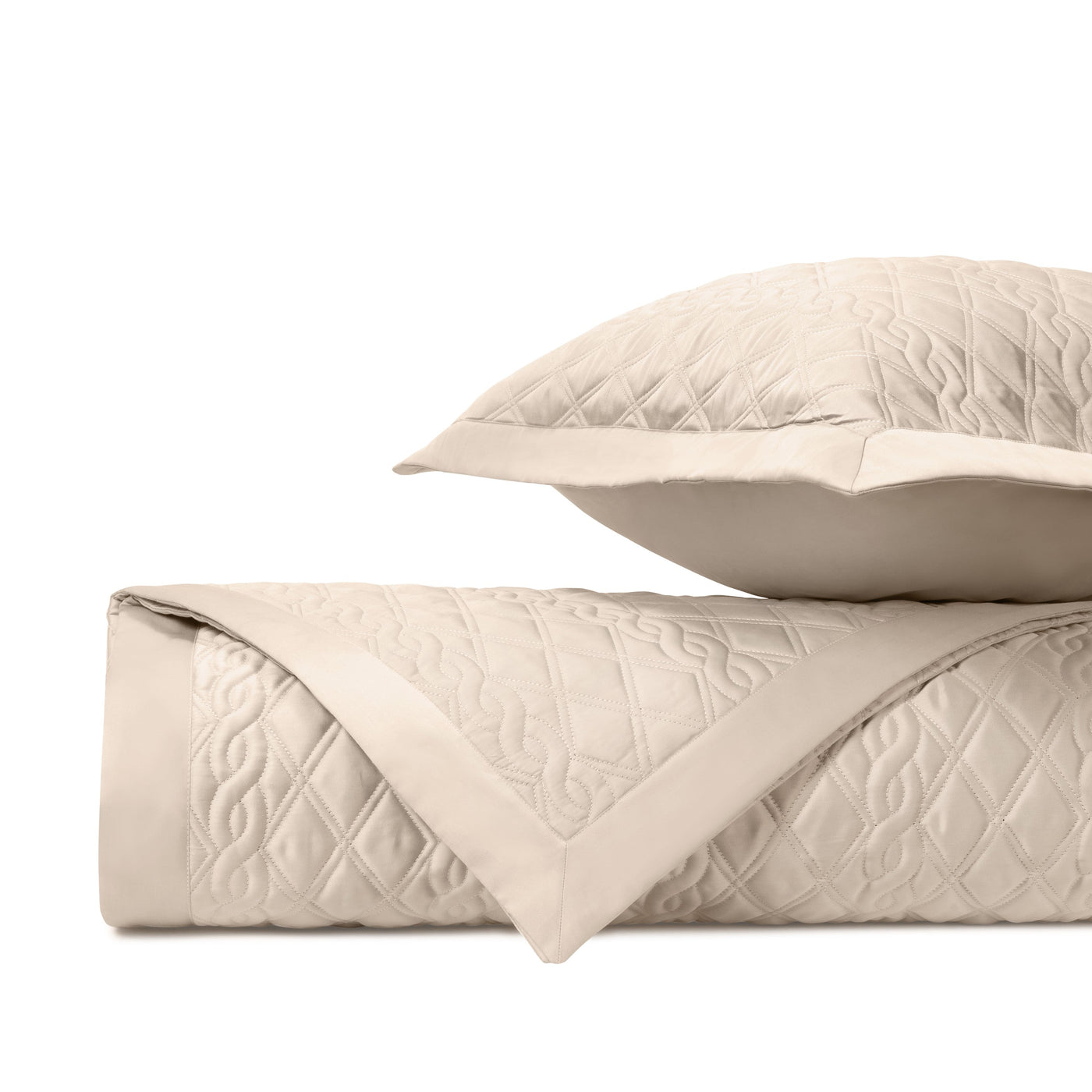 Close-up of Abbey quilted yardage in ivory with intricate diamond and scroll stitching.