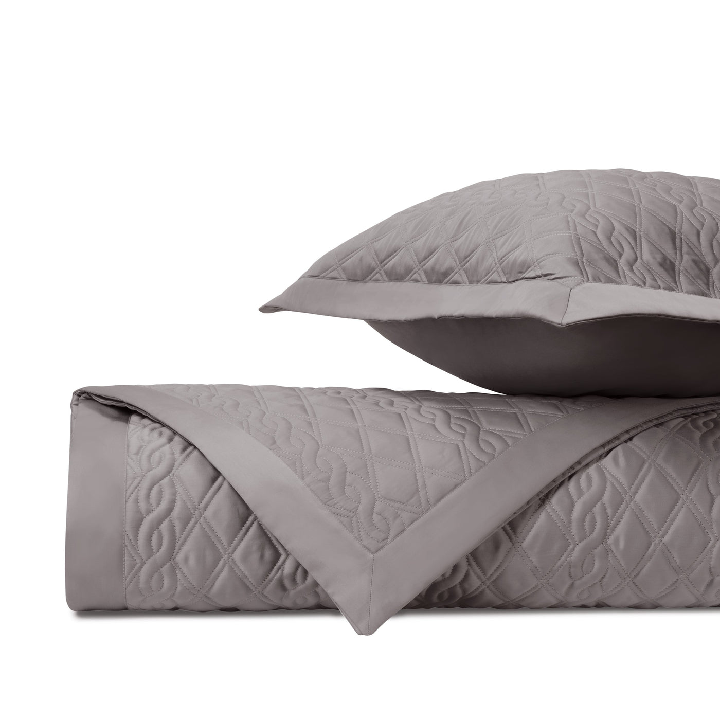 Close-up of Abbey quilted coverlet in taupe with diamond and scroll stitching detail.
