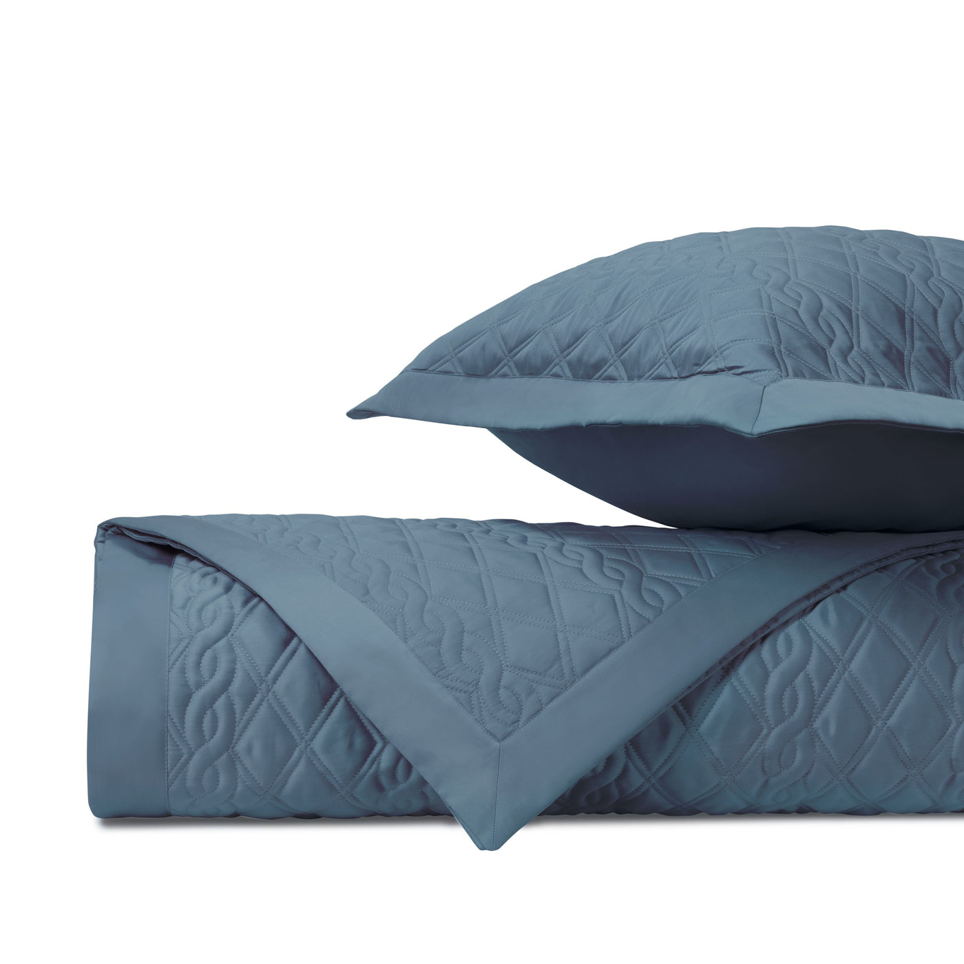 Close-up of Abbey quilted coverlet in slate blue, showing diamond and scroll stitch detail.