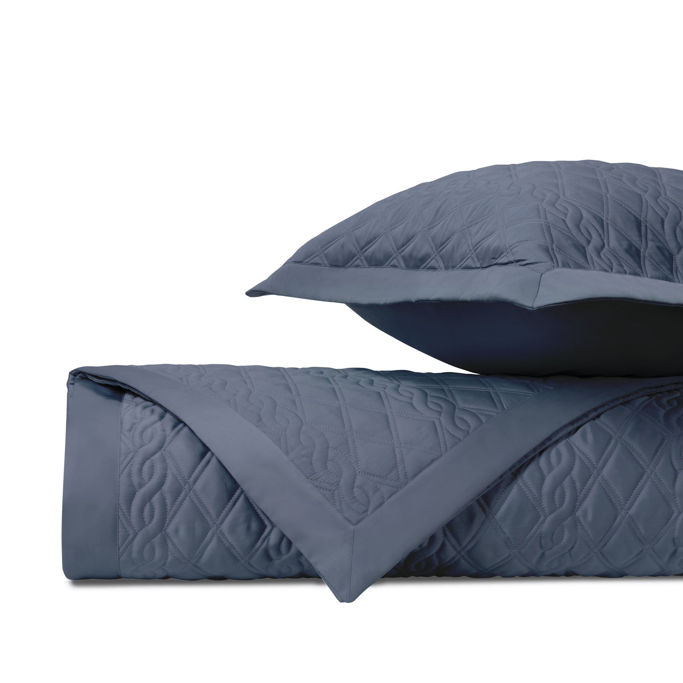 Close-up of Abbey quilted coverlet in slate blue, showing diamond stitch pattern and folded edge detail.