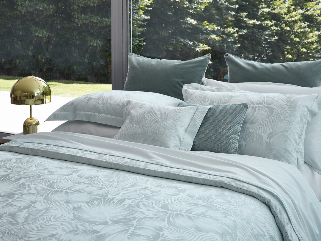 Close-up of Copacabana duvet cover in mist blue with tonal leaf jacquard pattern.
