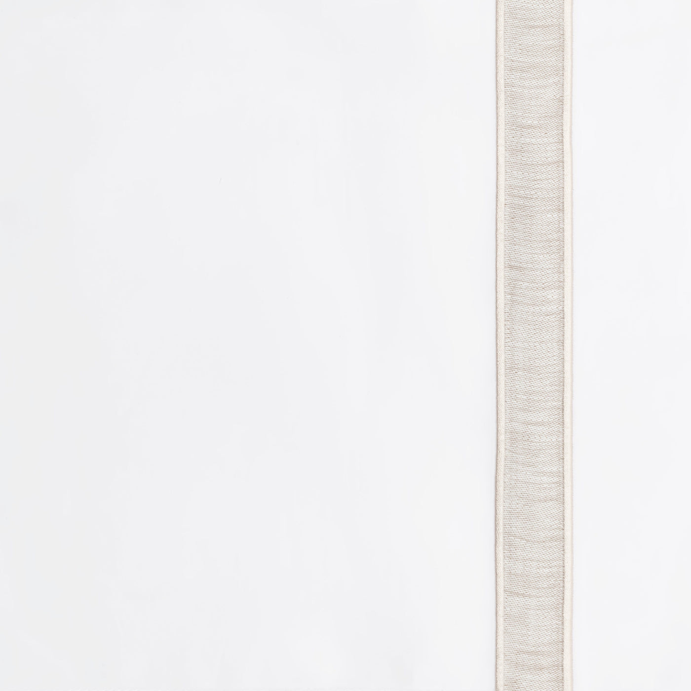 Close-up of woven natural linen border trim against ivory fabric edge.