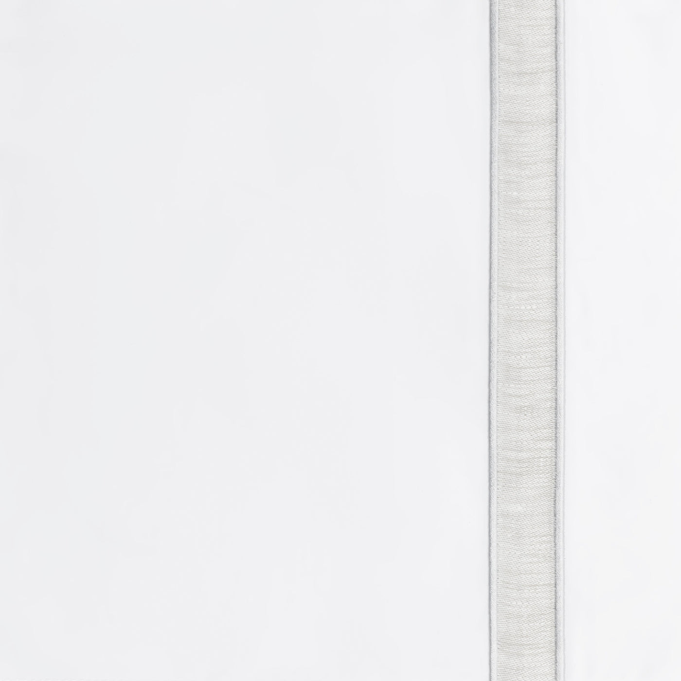 Close-up of woven silver border detail on white Home Treasures Alina linen.