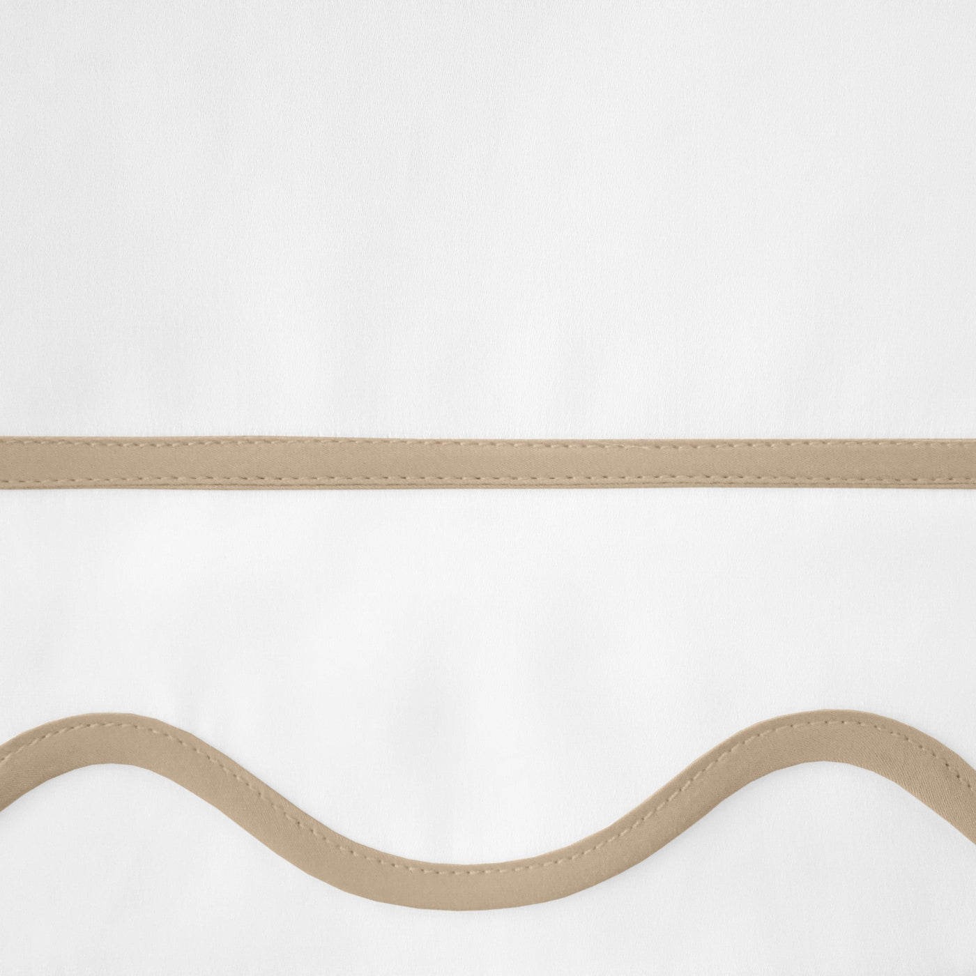 Close-up of straight and scalloped camel trim options on white linen fabric.