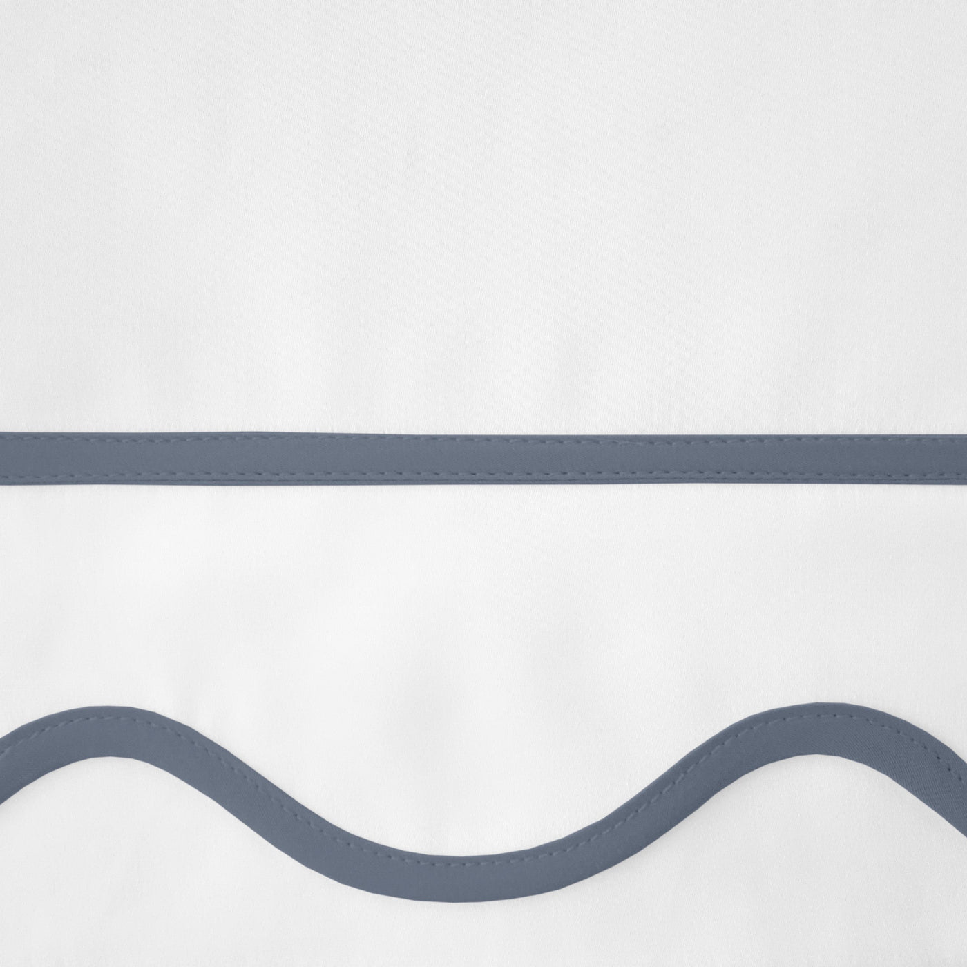 Close-up of slate blue wave and straight-line embroidery on white cotton fabric.
