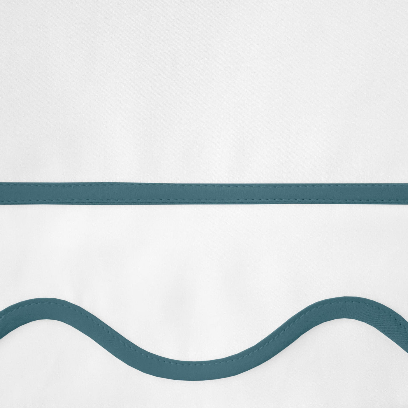 Close-up of teal wave and straight-line embroidery details on white linen.