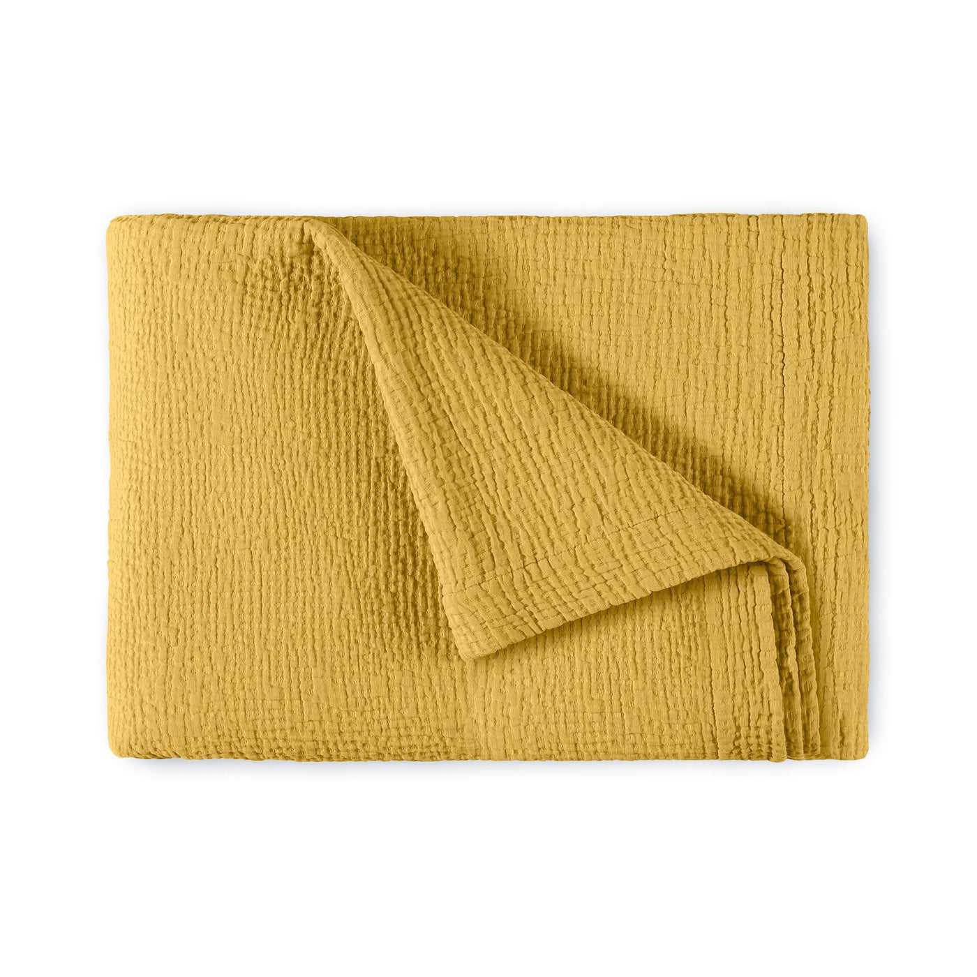 Amalia Home Collection Areia bedspread folded in saffron, showing textured cotton weave detail.