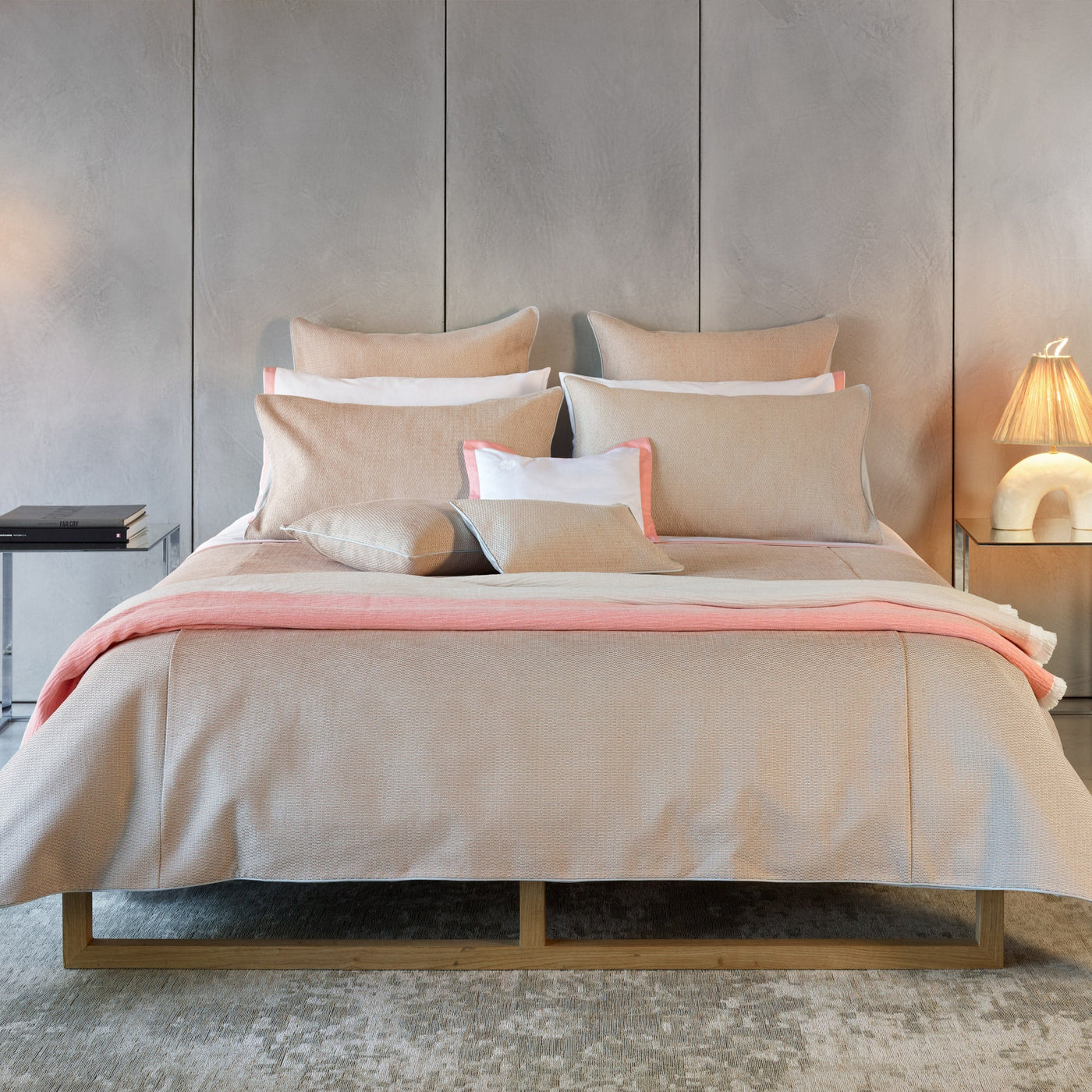 Champagne linen-textured euro sham with coral and white border detail on styled bed.
