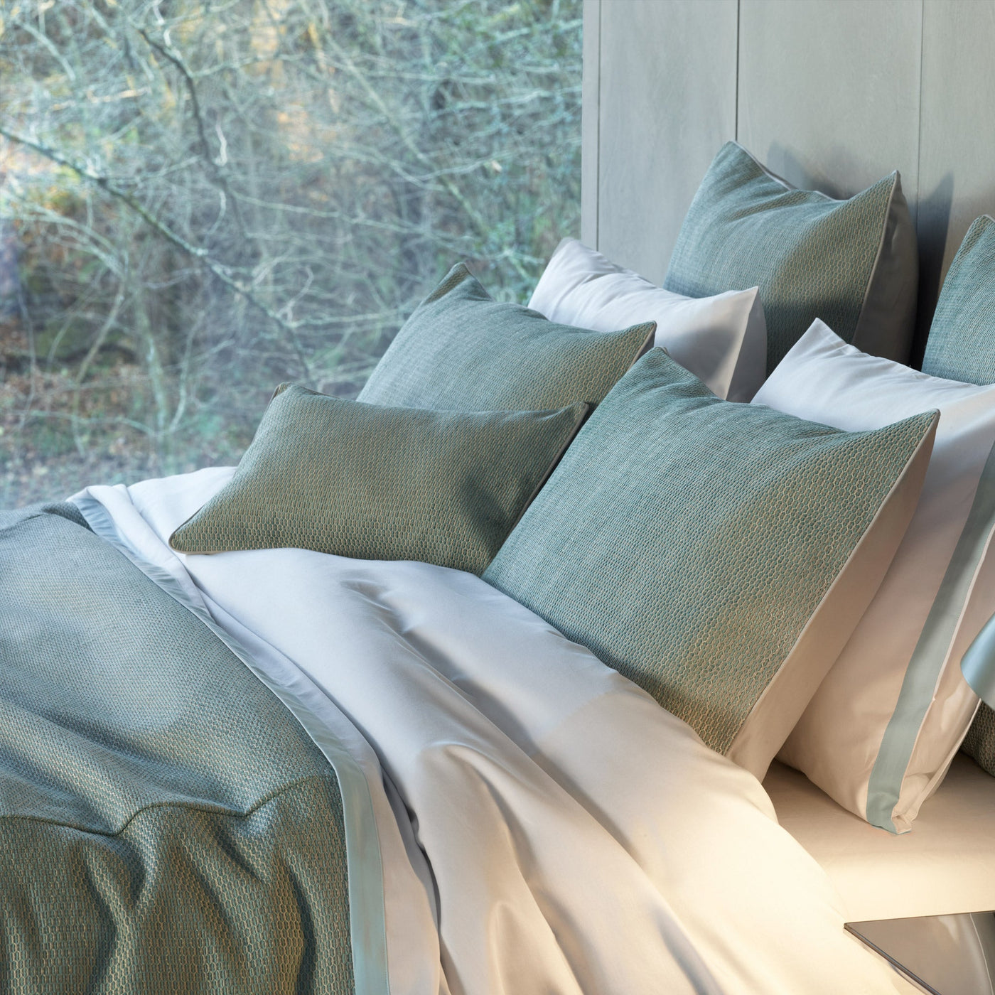 Sage green textured euro sham layered with white bedding, natural window light backdrop.