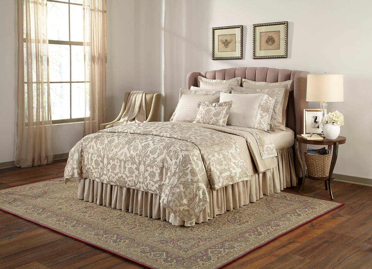 Champagne jacquard damask bedding set styled on a bed with matching bed skirt and pillows.
