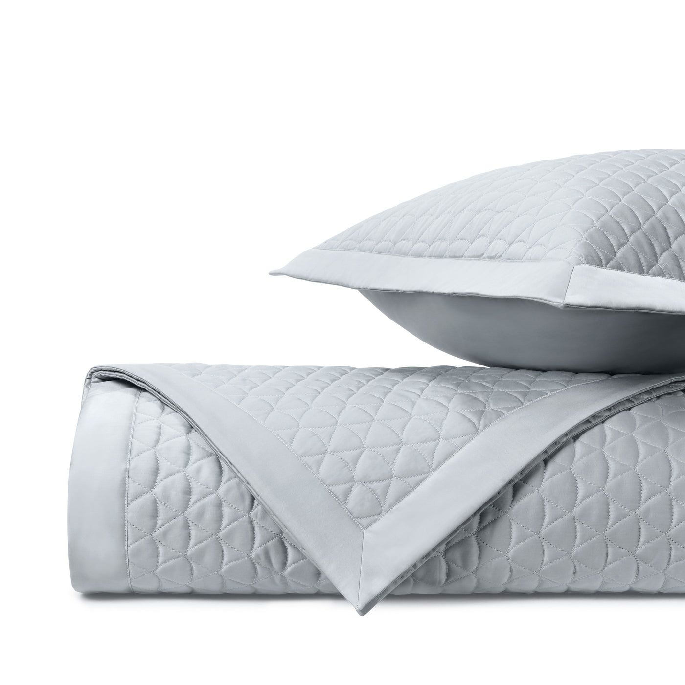 Close-up of silver quilted diamond stitching with white satin border trim.