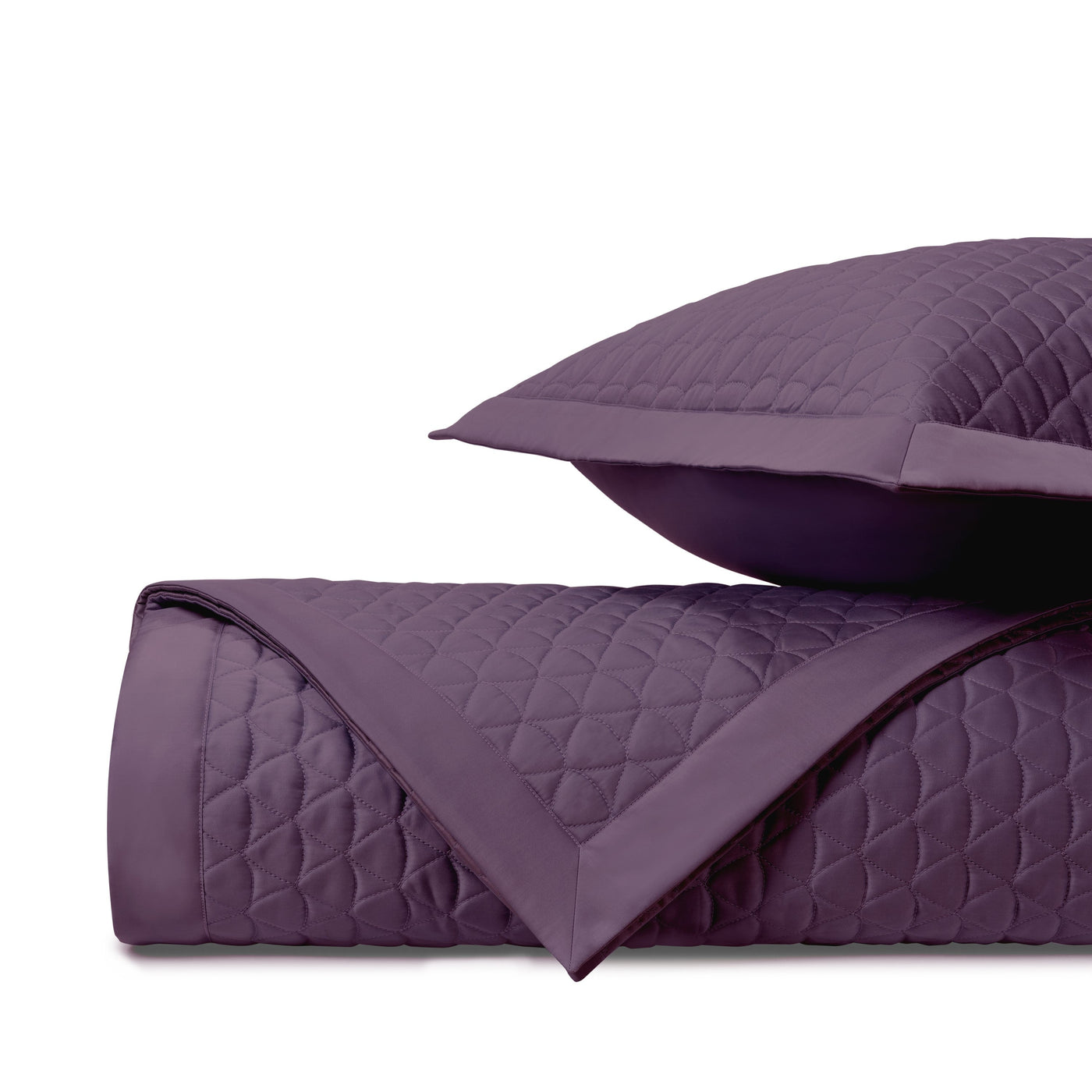 Close-up of amethyst quilted coverlet with diamond stitching pattern and coordinating sham.