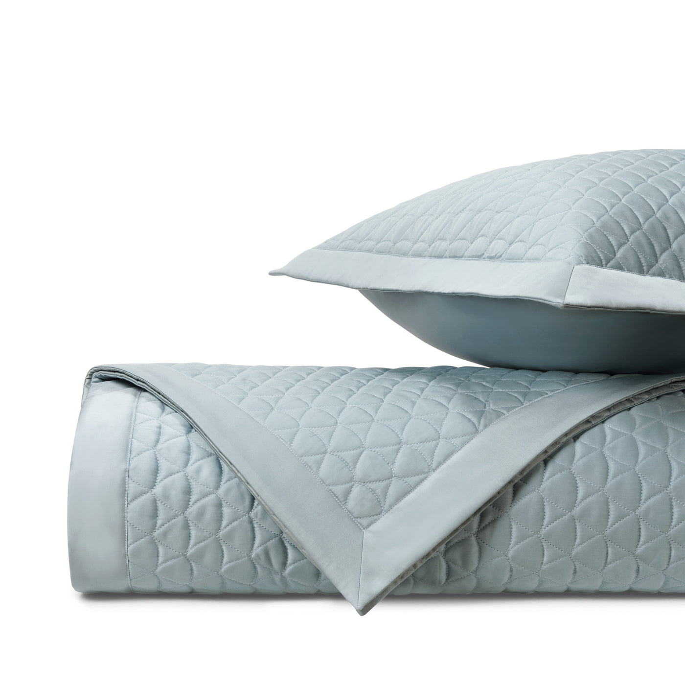 Close-up of quilted diamond-pattern coverlet and sham in mist blue with satin border trim.