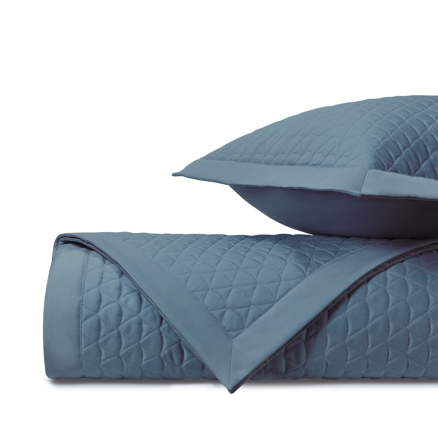 Close-up of Anastasia quilted coverlet in slate blue with diamond stitching pattern.