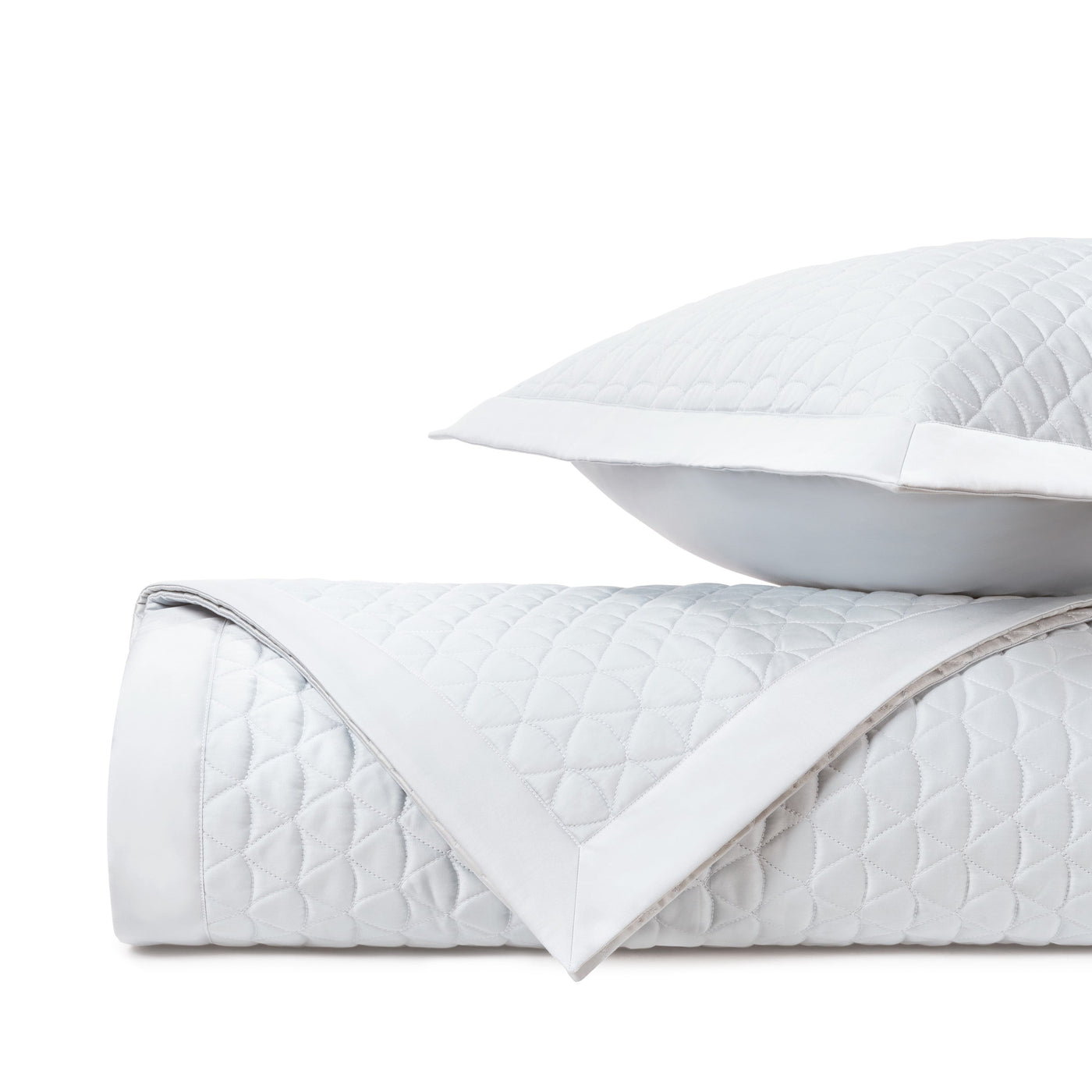 Close-up of white quilted diamond-pattern fabric with a clean white border edge.