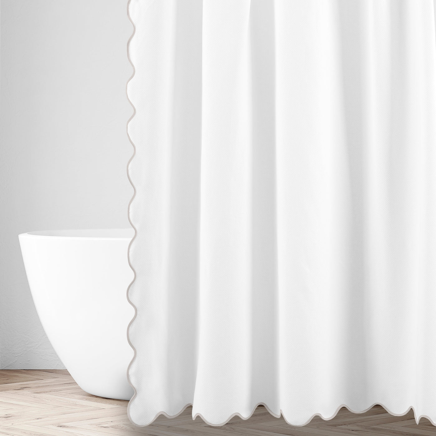 White shower curtain with scalloped edge trim, styled in a bathroom with freestanding tub.