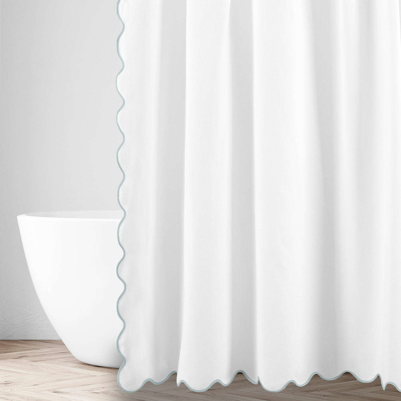 White shower curtain with seafoam scalloped trim edge, styled in a bright bathroom setting.
