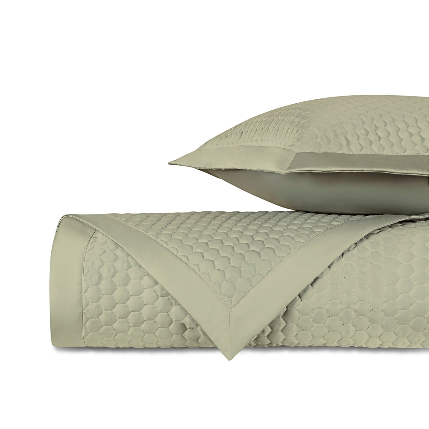 Close-up of sage quilted fabric with honeycomb texture and satin border trim.