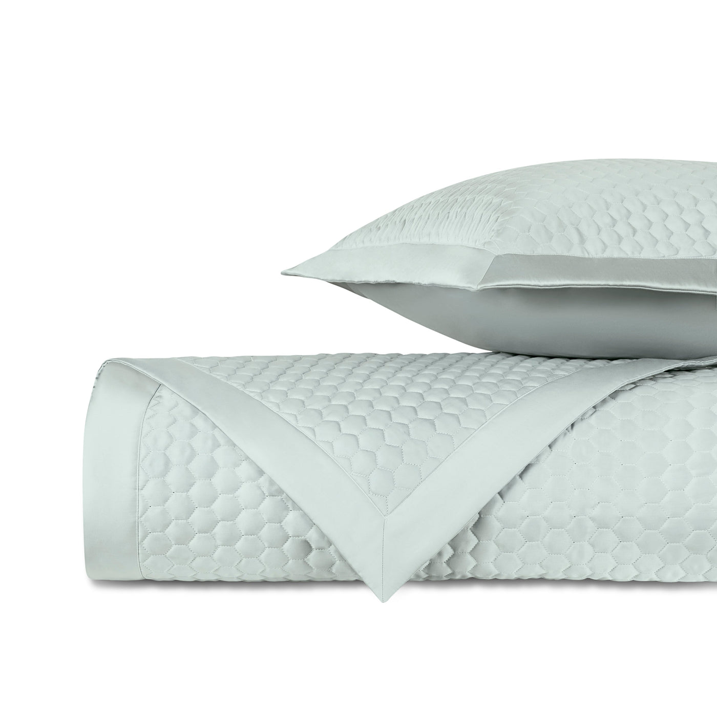Close-up of Apiary quilted yardage in mist, showing honeycomb texture and satin border trim.