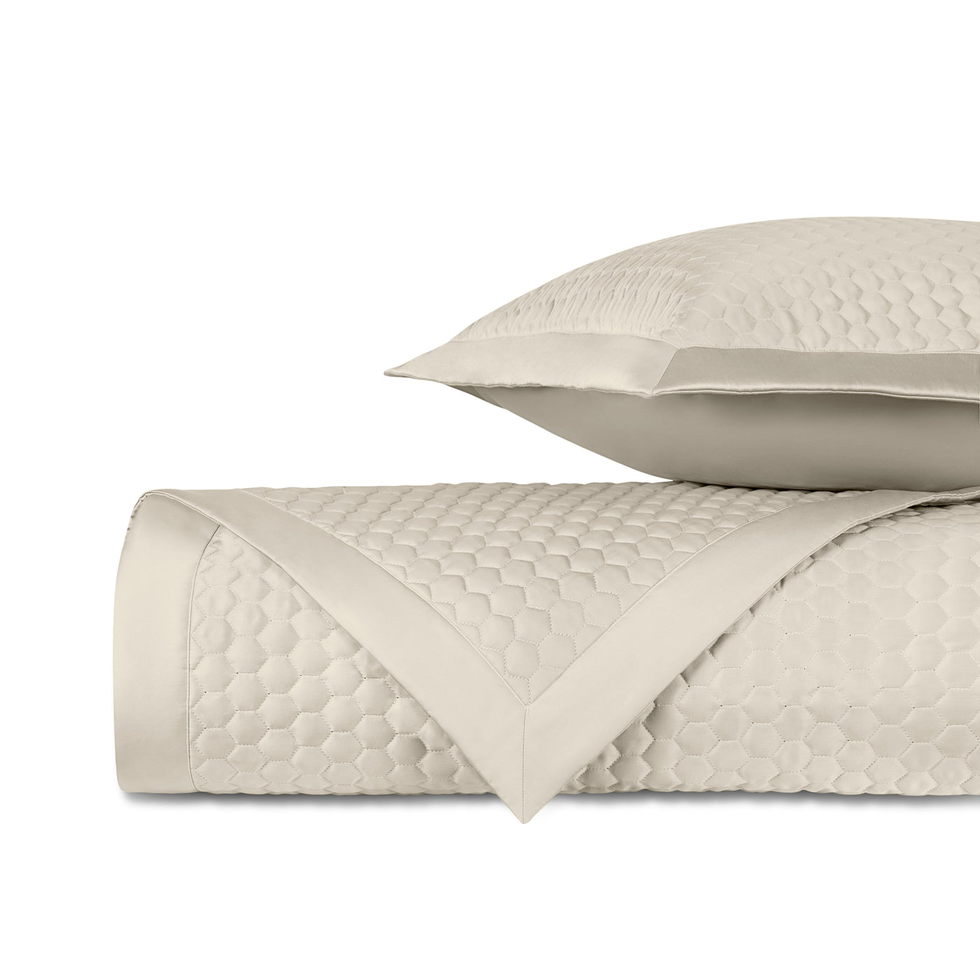 Close-up of ivory quilted honeycomb texture with satin border trim.