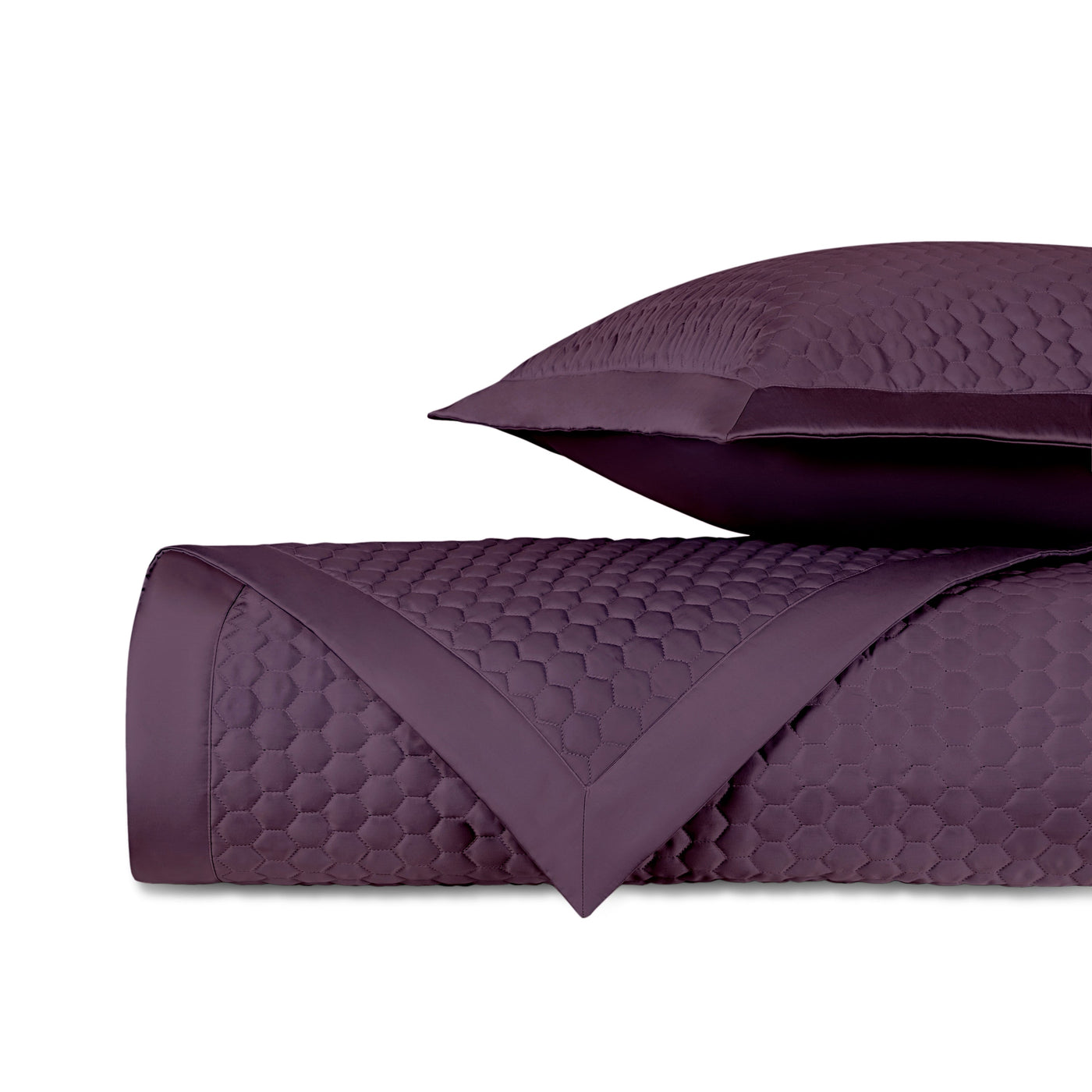 Close-up of Apiary quilted yardage in deep plum with honeycomb texture and satin border trim.