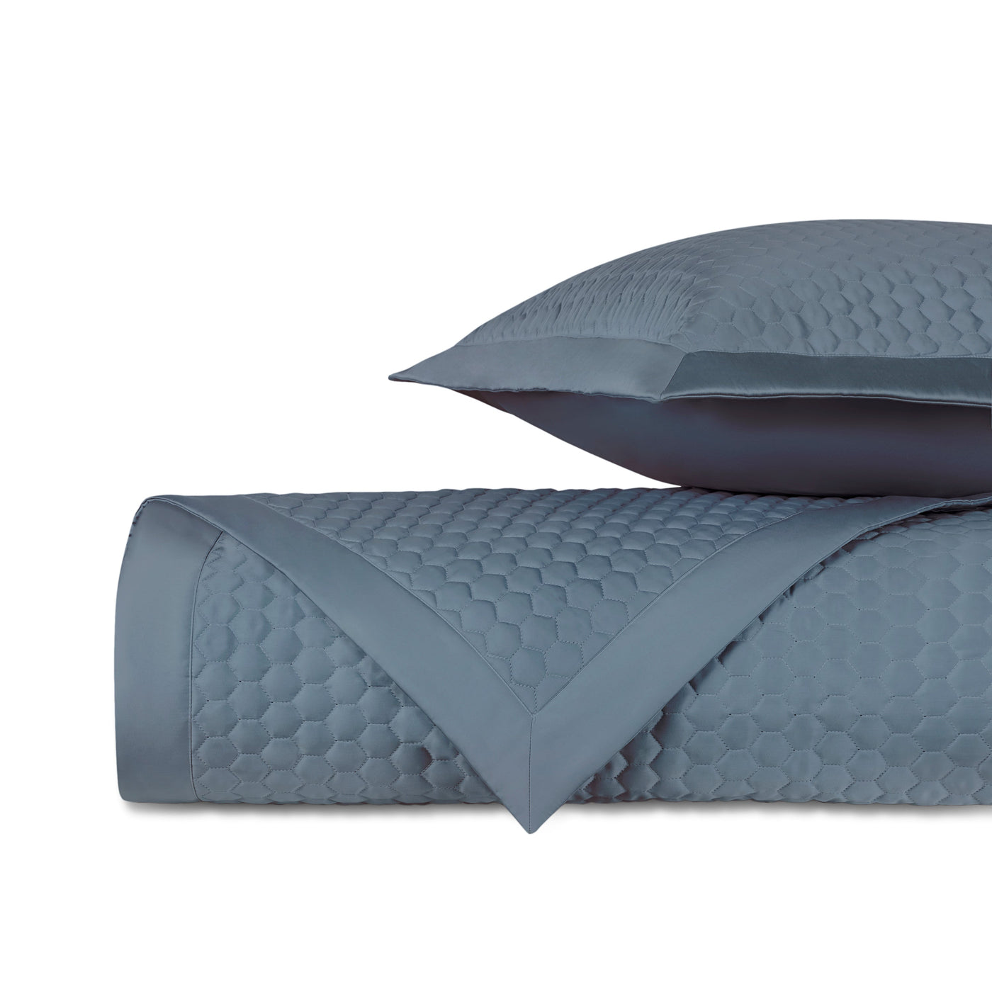 Close-up of Apiary quilted coverlet in slate blue with honeycomb texture detail.