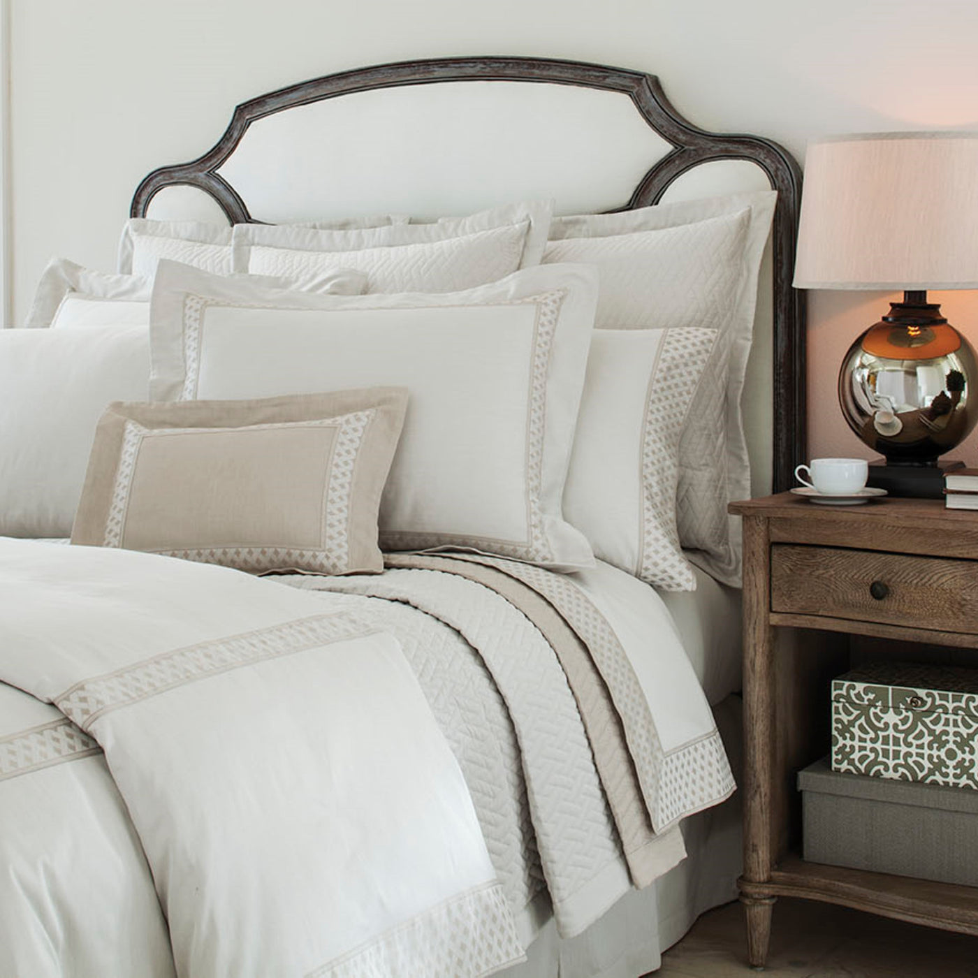 Home Treasures Ara ivory and champagne geometric border bedding styled on bed.