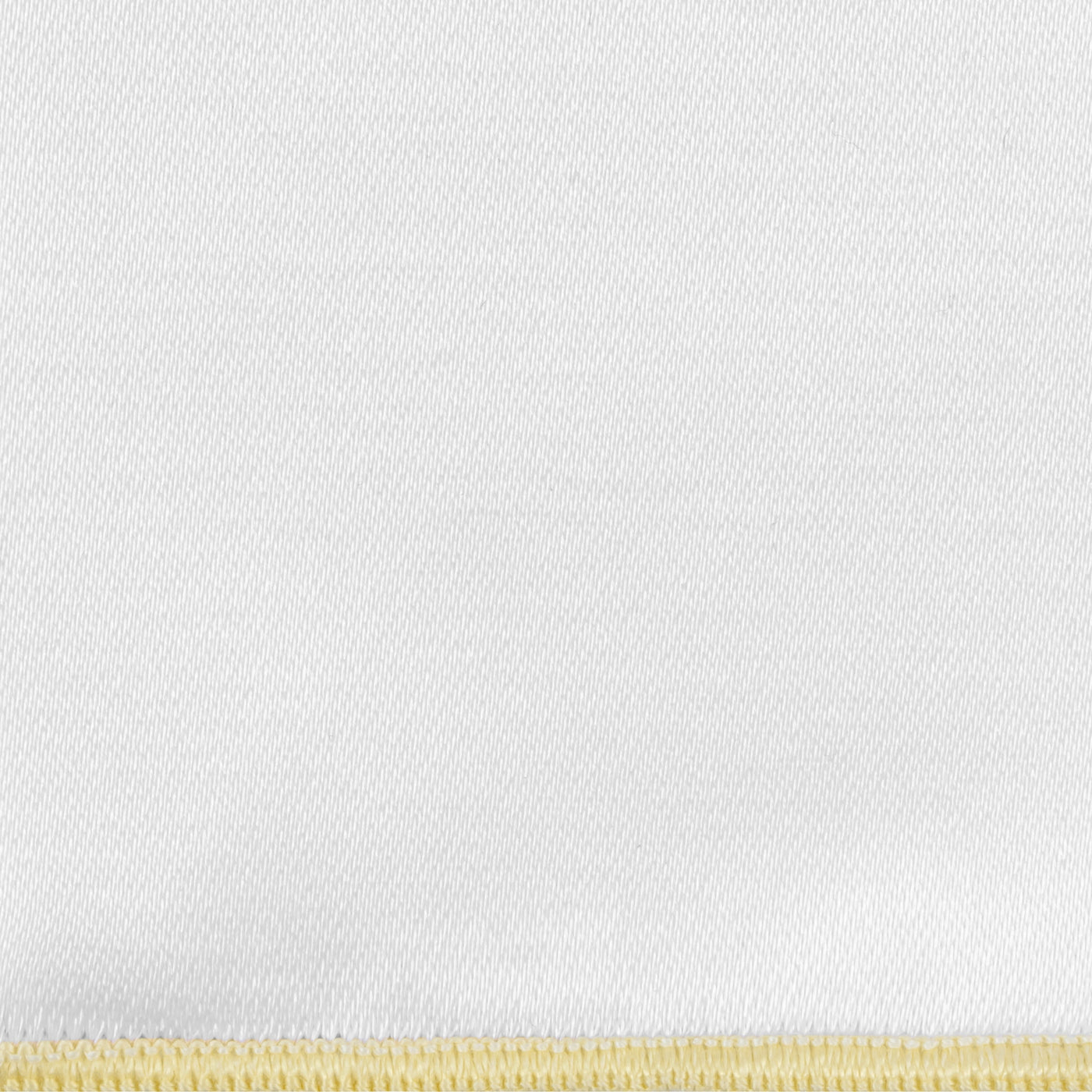 Close-up of white woven fabric with a buttercup yellow blanket-stitch border detail.